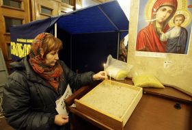 A woman puts a candle