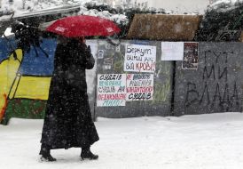 A woman passes near barricades