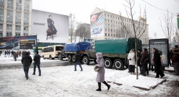 Cars with soldiers of internal troops partitioned off a street