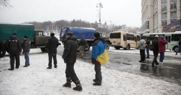 Cars with soldiers of internal troops partitioned off a street