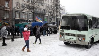 Cars with soldiers of internal troops partitioned off a street