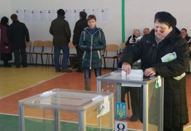 The woman drops his ballot in the ballot box