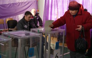 The woman drops his ballot in the ballot box