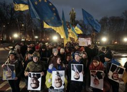 Участники акции держат перевернутые плакаты