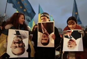 Участники акции держат перевернутые плакаты