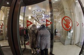 Люди входять в Головний універсальний магазин (ГУМ)