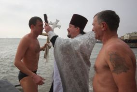 Мужчина прикладывается к кресту