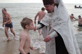Мальчик прикладывается к кресту