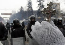 A priest holds a cross