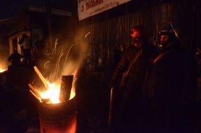 Protesters are heated by the fire