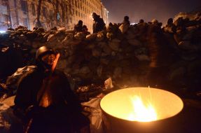 Protesters are heated by the fire
