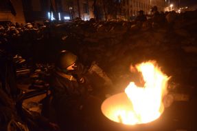 Protesters are heated by the fire