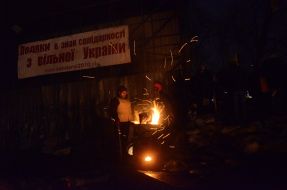 Protesters are heated by the fire