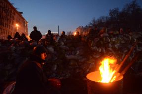 Protesters are heated by the fire
