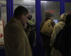 People are standing in front of the closed entrance to the metro station