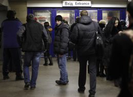 Люди стоять перед закритим входом на станцію метро