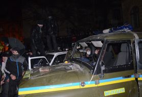 Protesters smash police car