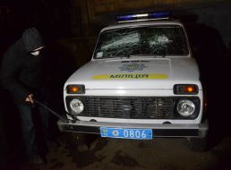 Protesters smash police car