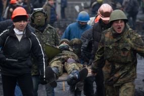 Protesters carry a wounded