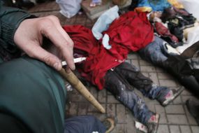 A man smokes near slain protesters