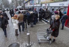 Люди стоять у черзі до банкомату