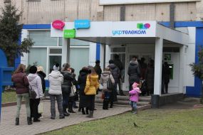 Люди стоять у черзі до банкомату