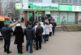 Люди стоять у черзі до банкомату