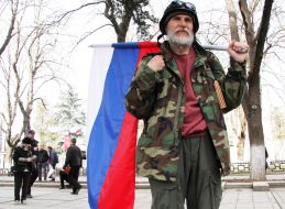 A man holding a flag of the Russian Federation