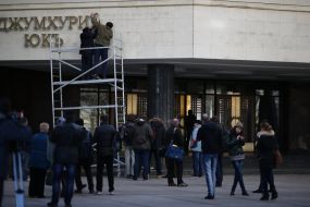 Workers take off a signboard from building of Crimea parliament 