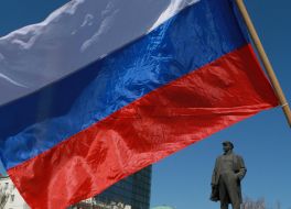 Flag of Russia near a monument to Lenin