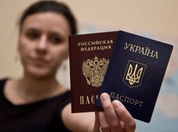 Girl holds Russian and Ukrainian passports