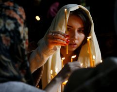 A woman puts a candle