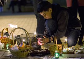 A boy kindles a candle 