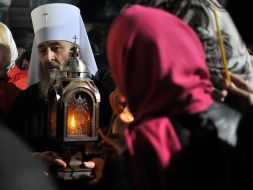 Митрополит Онуфрий держит Благодатный огонь