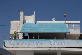 Worker paints a wall cafe on the waterfront