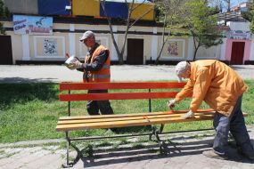 Workers paint the town municipal service bench