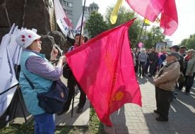 The elderly woman holds a flag