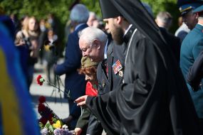 People lay flowers to the monument