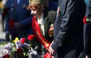 People lay flowers to the monument