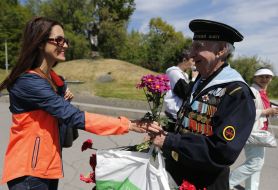 Дівчина дарує квіти ветерану