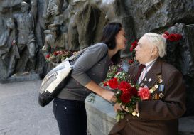 Дівчина дарує квіти ветерану