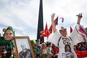 A woman holds  the portrait of the marshal Zhukov
