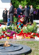 A girl lays flowers to the Eternal fire