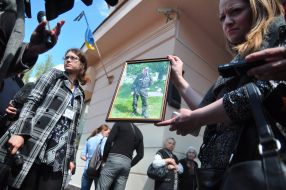 Woman holding a photograph of Oleg Eysmant