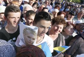 A young man holds a placard