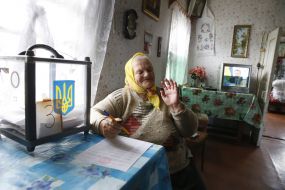 An elderly woman votes on to the house