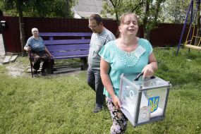 Пожилая женщина голосует на дому