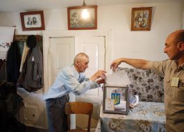 Пожилой мужчина голосует на дому