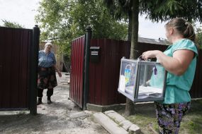 Пожилая женщина голосует на дому