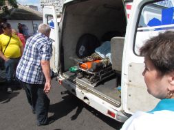 Workers the ambulance near shot car